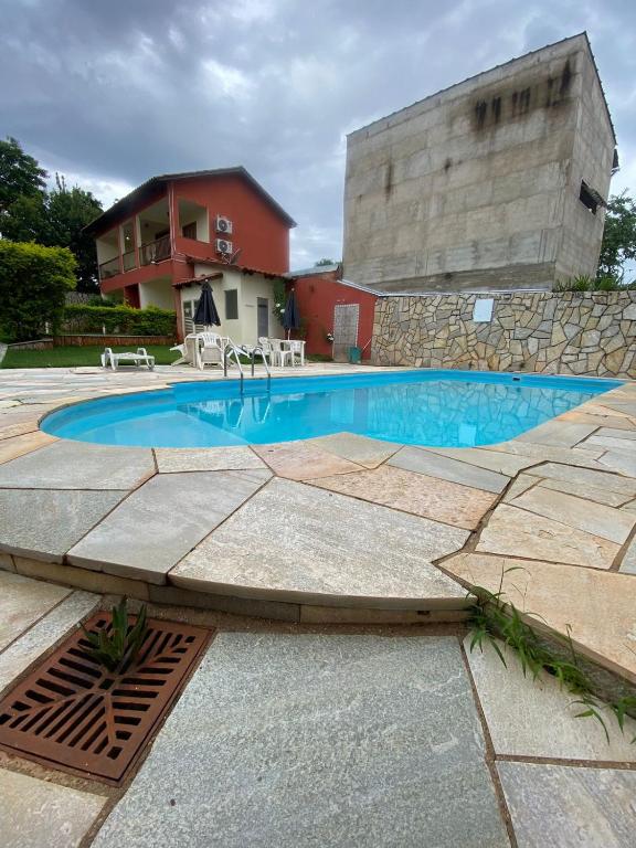 a swimming pool in front of a building at Villa Zen Pirenópolis Conforto e Bem-Estar in Pirenópolis