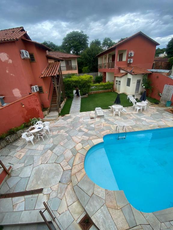 a swimming pool in a yard with two buildings at Villa Zen Pirenópolis Conforto e Bem-Estar in Pirenópolis