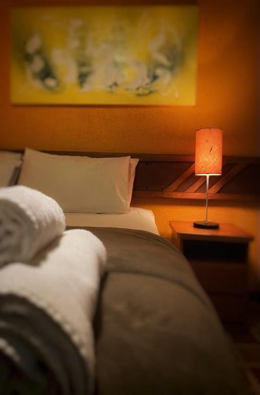 a bedroom with a bed and a table with a lamp at Villa Zen Pirenópolis Conforto e Bem-Estar in Pirenópolis