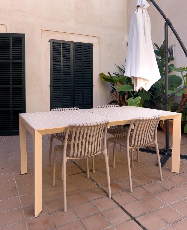 a wooden table with two chairs and an umbrella at Ramón Llull House in Palma de Mallorca