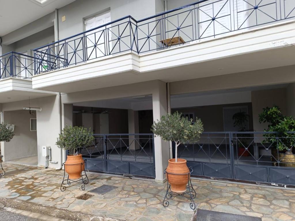 a building with two potted trees in front of it at Paws & Relax Retreat in Kalabaka