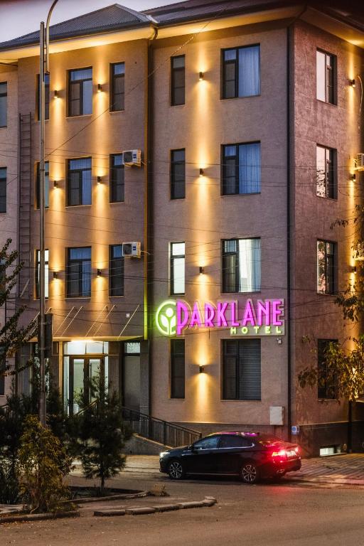 a building with a sign on the side of it at Parklane Hotel in Tashkent