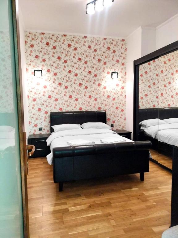 a bedroom with two beds and a floral wall at Casa Albert Litman in Sinaia