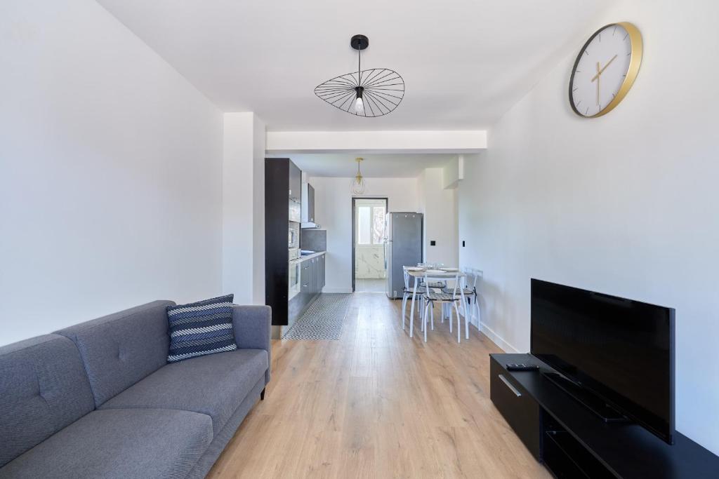 un salon avec un canapé et une horloge au mur dans l'établissement Appartement Sérénité Normande - Welkeys, à Cabourg