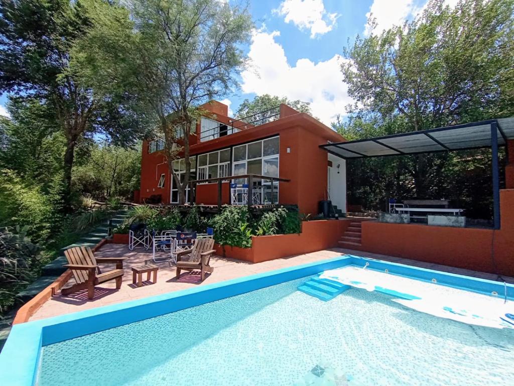 a home with a swimming pool and a house at Alondra Boutique in Villa Cura Brochero