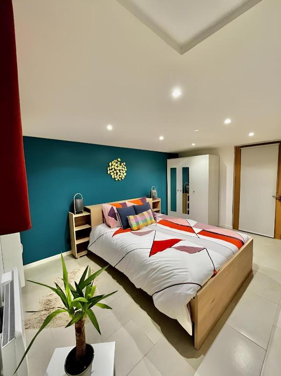 une chambre avec un grand lit et un mur bleu dans l'établissement Logement entier, à Bourges
