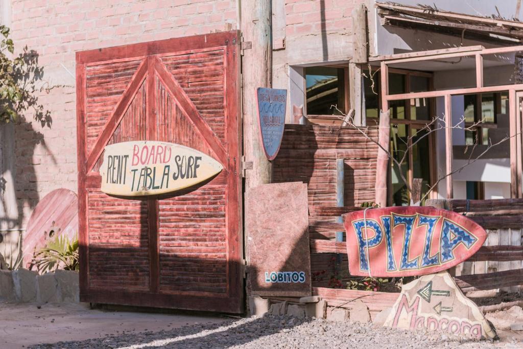 a brick building with signs on the side of it at Hotel Relajate in Lobitos