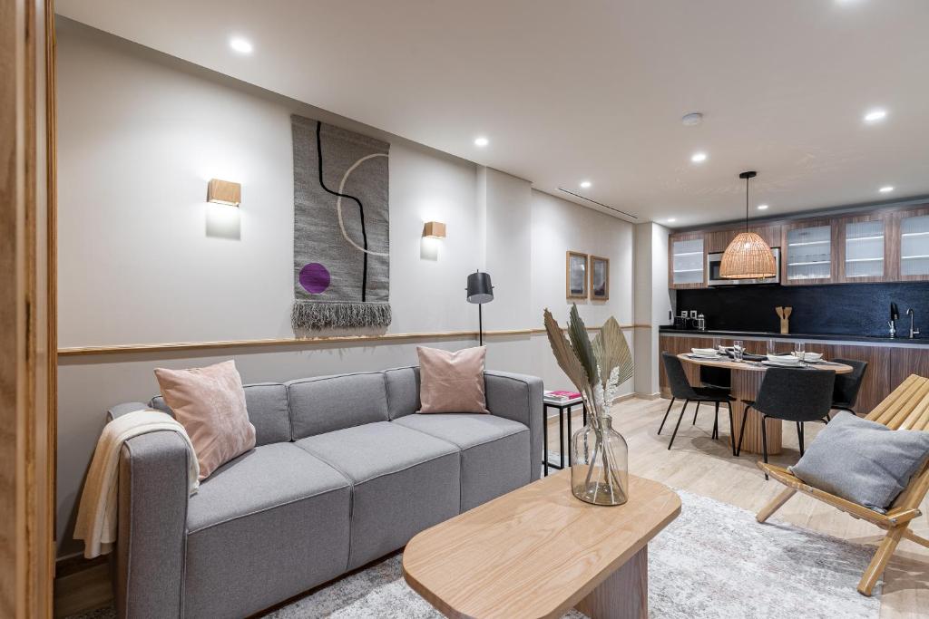 A styled living room opening onto a compact dining and kitchen area.
