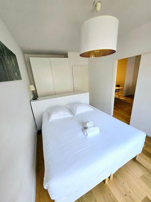 - une chambre avec un lit blanc éclairé dans l'établissement Appartement Grand T2 Hypercentre, à Bordeaux