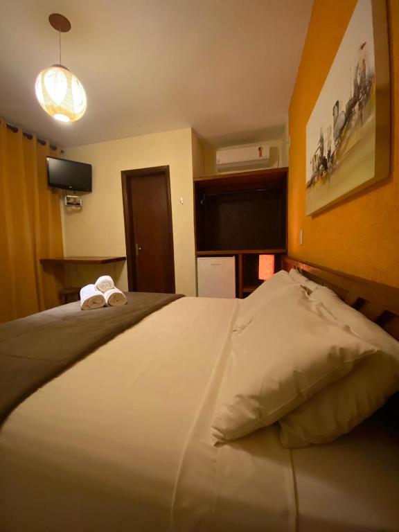 a bedroom with a bed with two towels on it at Villa Zen Pirenópolis Conforto e Bem-Estar in Pirenópolis