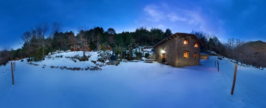 una casa en la nieve con luces encendidas en Casa rural alquiler íntegro Borda de Calvera para 9 personas, en Vilaller