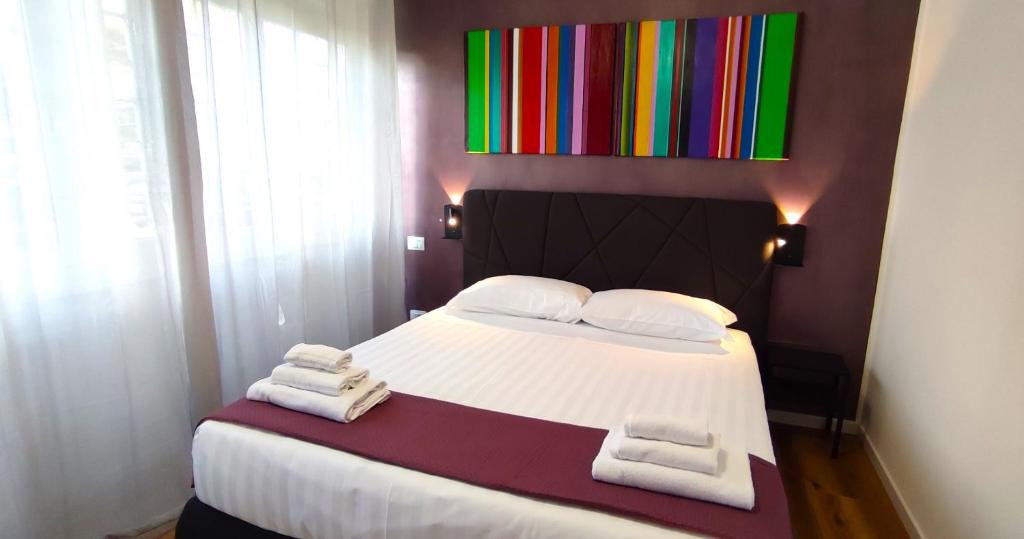a bedroom with a large bed with towels on it at Ancient Rome Colosseum modern and bright apartment in Rome