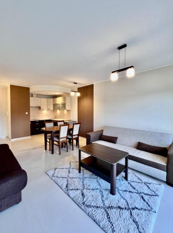 a living room with a couch and a table at Apartament Spacerowa in Grzybowo