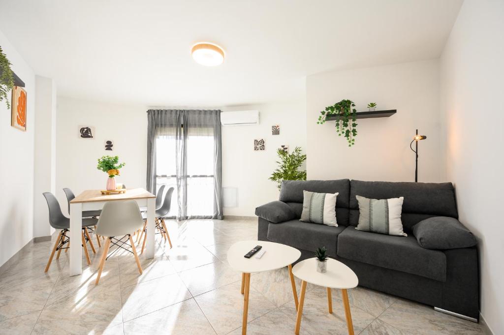 a living room with a black couch and a table at Cautivo 2 in Estepona