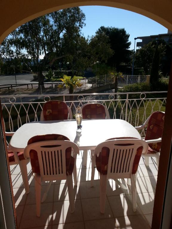 a white table and chairs on a balcony at bleu marine in Bormes-les-Mimosas