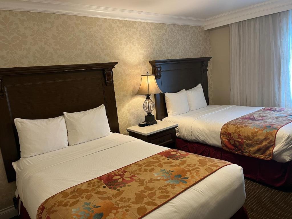 a hotel room with two beds and a window at Arbutus Inn in Victoria