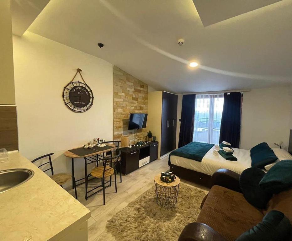 a bedroom with a bed and a kitchen with a table at Milmari kop in Raška