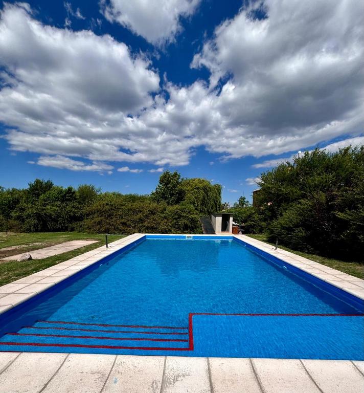 a swimming pool with blue water and a cloudy sky at Seven Hotel - Juana Koslay San Luis in Juana Koslay 