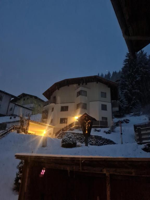 un edificio en la nieve por la noche en Haus "Die Zinne", en Außervillgraten