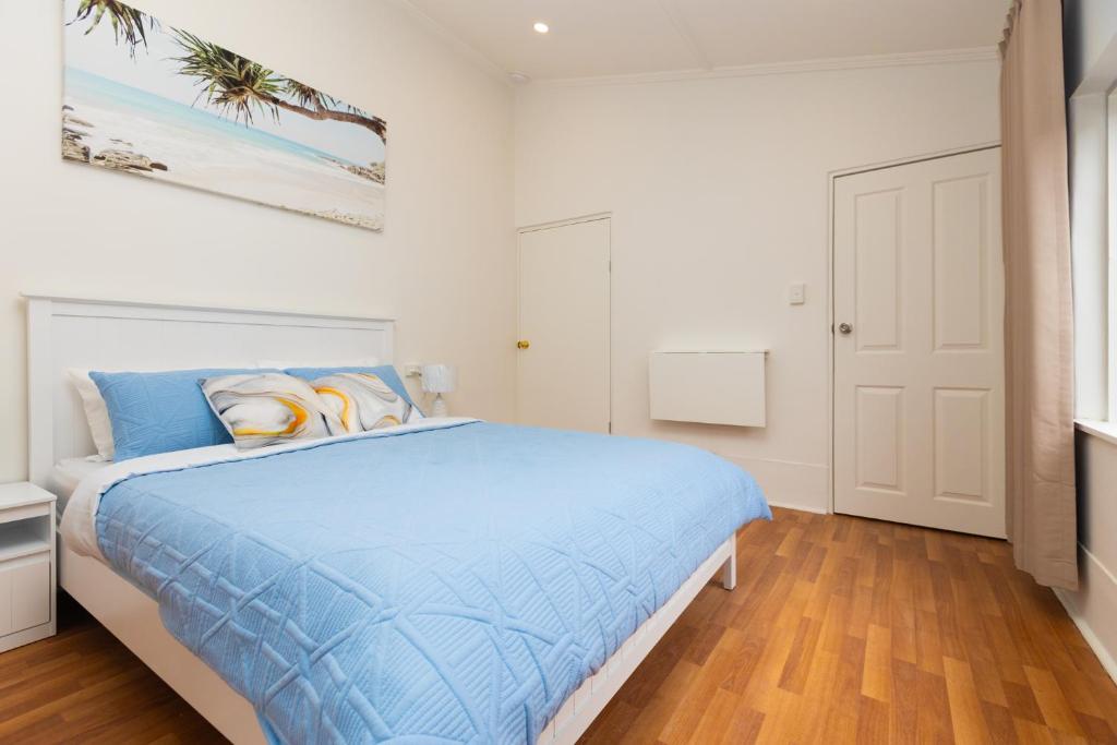 Un dormitorio con una cama con un edredón azul. en Glenelg Modern Studio, QBed,Wifi, en Glenelg