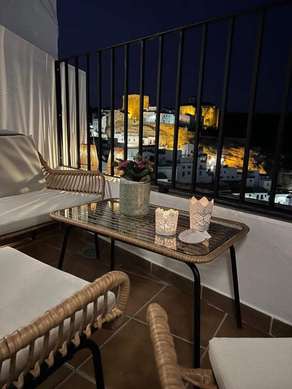 Un balcón con una mesa y vista a una ciudad. en Casa Rural Abril, en Setenil