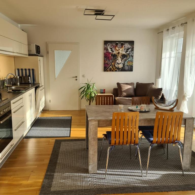 a kitchen and living room with a table and chairs at Apartment „Am Südhang“ in Adelzhausen