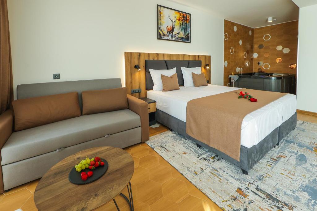 a hotel room with a bed and a couch at Lavalliere Hotel & Villas in Sarnitsa