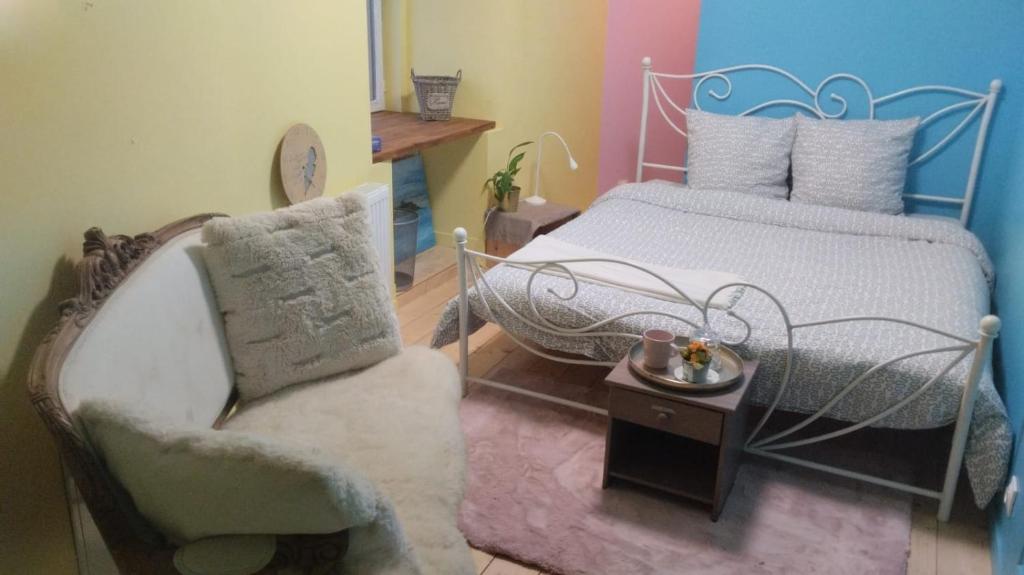 une chambre avec un lit, une chaise et une table dans l'établissement chambre du thé, sdb partagée, à Chavagne