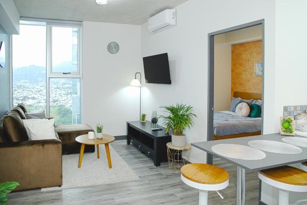 a living room with a bed and a dining room at Grotto at 28, City Views and Wonderland Vibes! in Hatillo