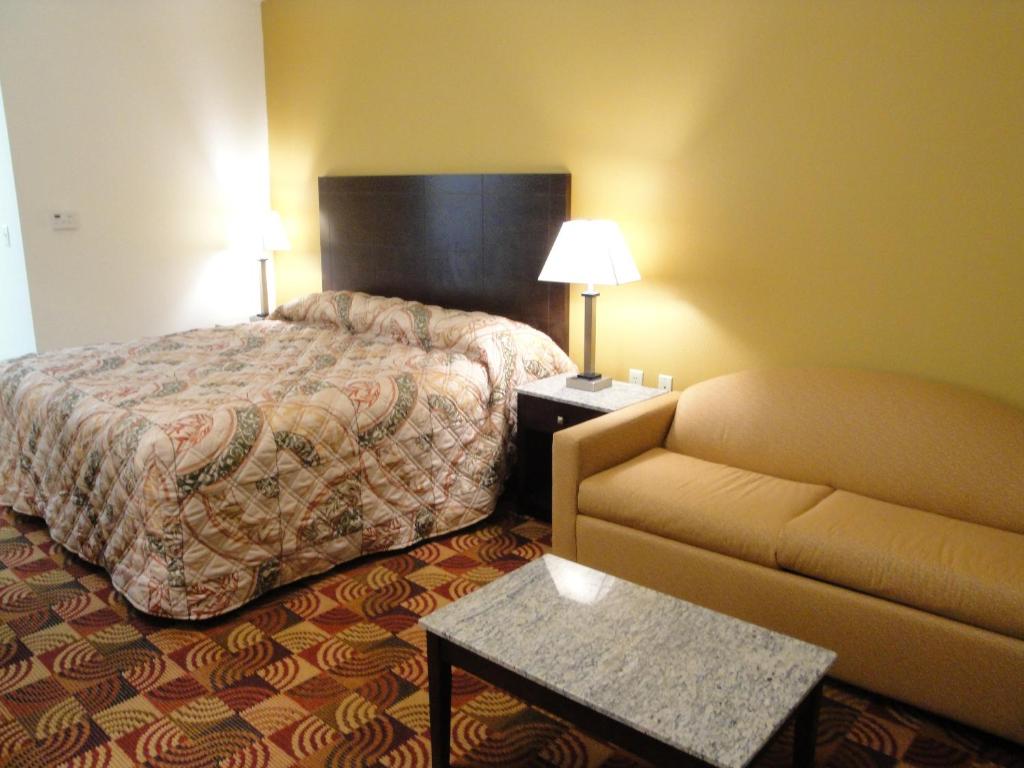 pokój hotelowy z łóżkiem i kanapą w obiekcie Sands Inn & Suites w mieście Woodward