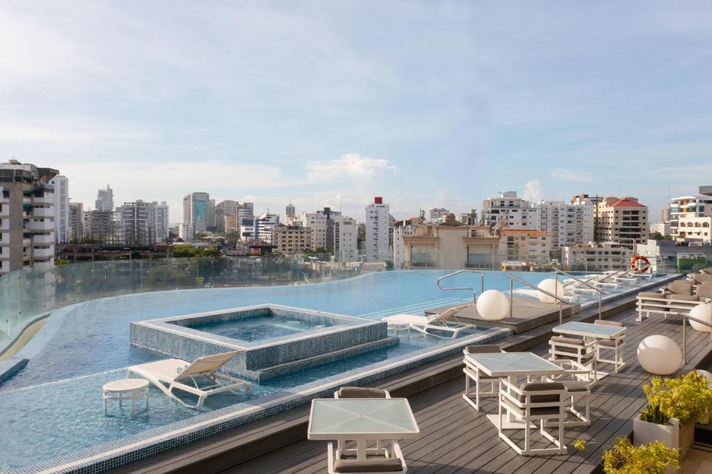 a swimming pool on the roof of a building at Embassy Suites by Hilton Santo Domingo in Santo Domingo