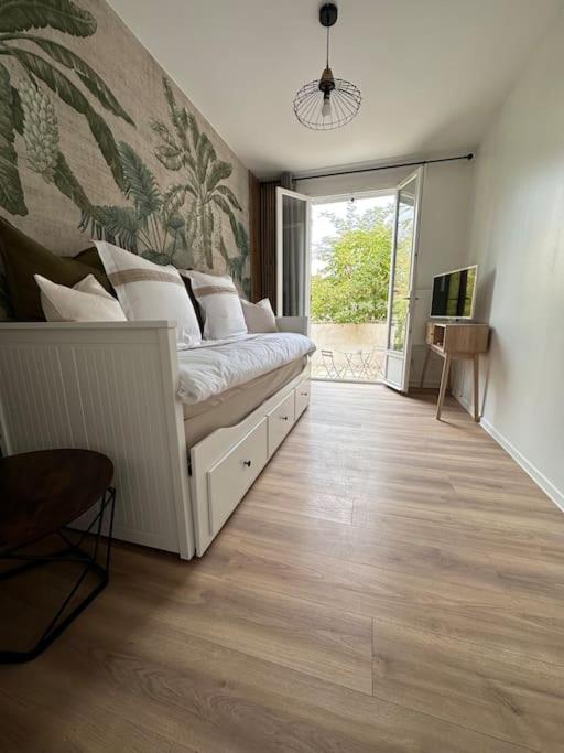 - un salon avec un lit blanc dans l'établissement Appartement les Lilas, à Dijon