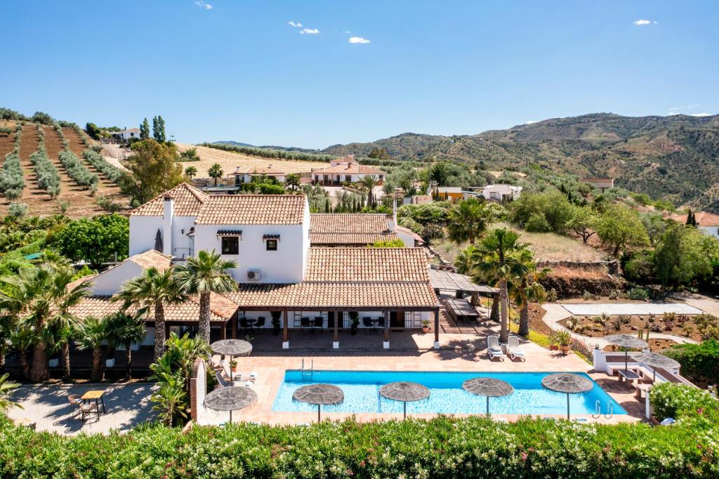 een luchtzicht op een villa met een zwembad en palmbomen bij Hacienda Riogordo in Ríogordo