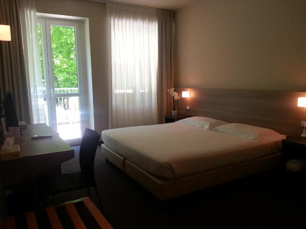 pokój hotelowy z łóżkiem i oknem w obiekcie HLL Hotel Lungolago Lecco-Como Lake w mieście Lecco