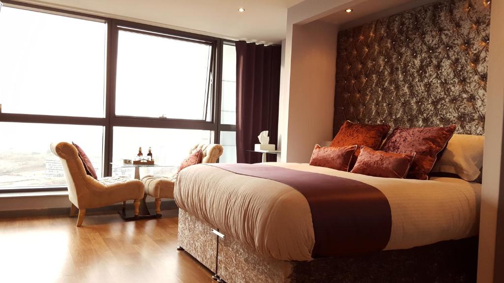 a bedroom with a large bed and a large window at City Atmosphere in Leeds