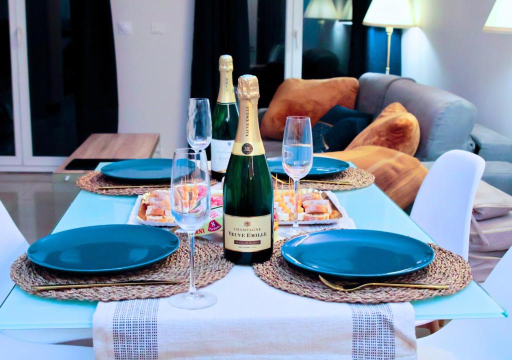 - une table avec une bouteille de vin et deux verres dans l'établissement Appartement-Paris-Disney-Terrasse-Jardin-parking, à Vaires-sur-Marne