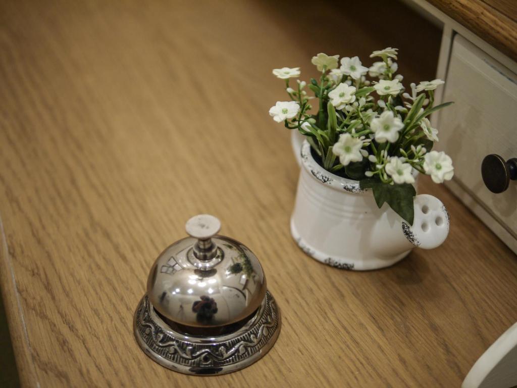 a table with a vase of flowers and a tea kettle at Bed Milano Linate in Milan