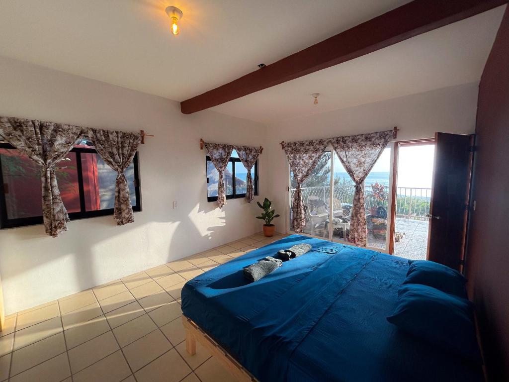 ein Schlafzimmer mit einem blauen Bett und einem Fenster in der Unterkunft Hotel Manava in Brisas de Zicatela