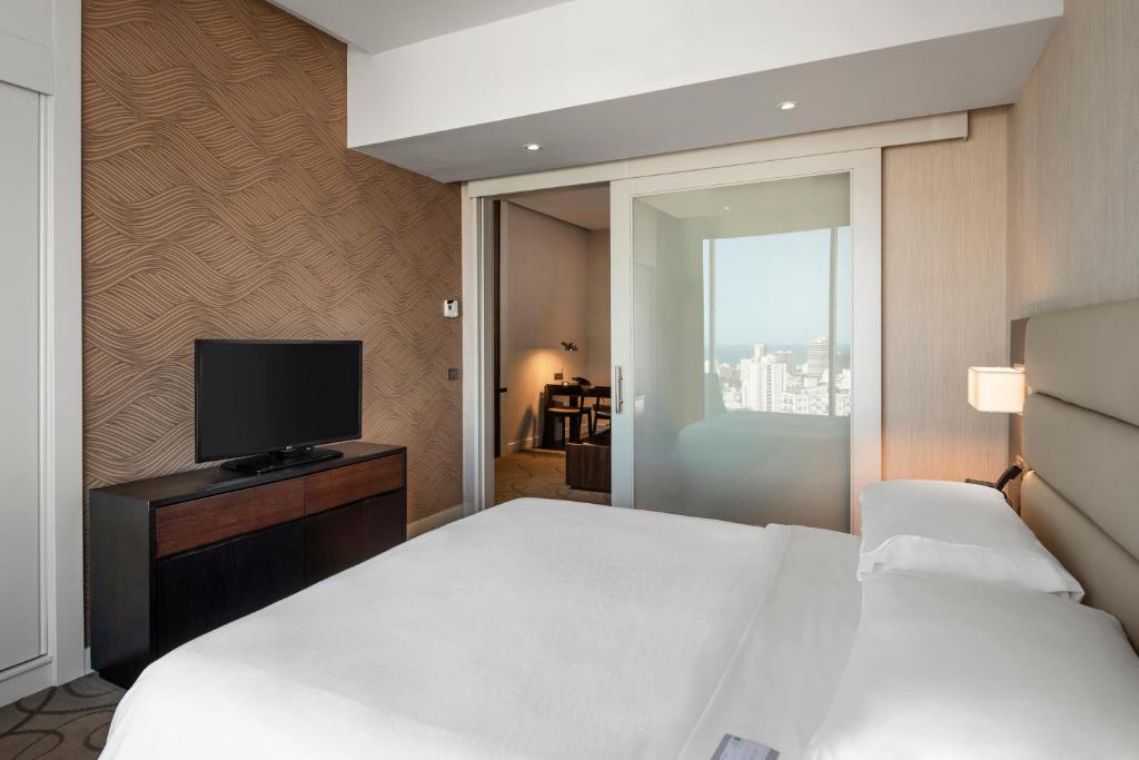 a hotel room with a bed and a television at Embassy Suites by Hilton Santo Domingo in Santo Domingo