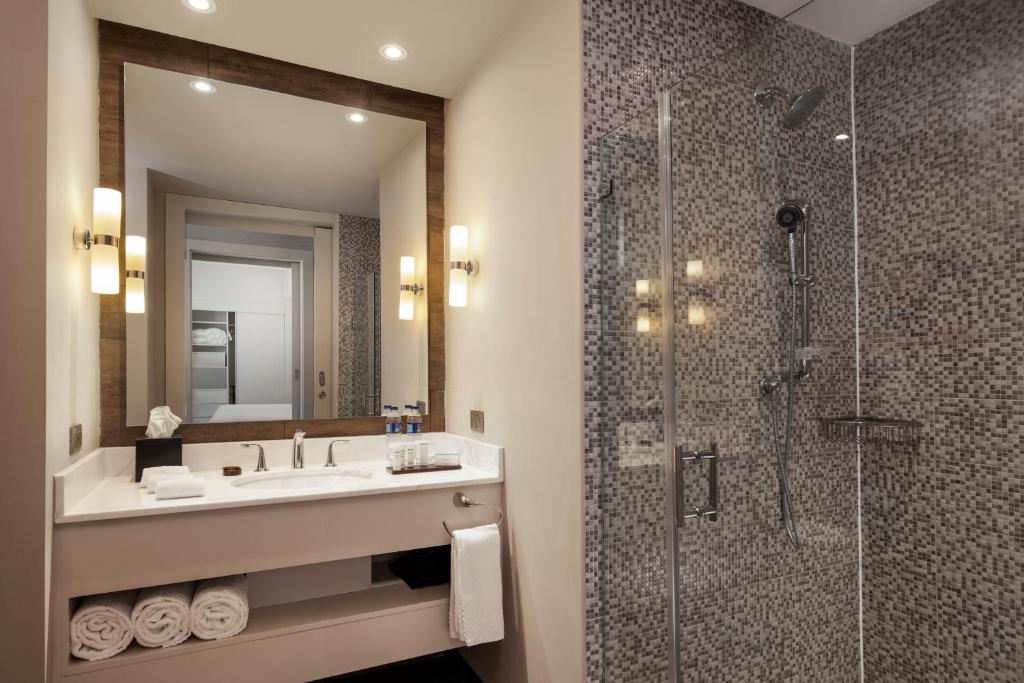 a bathroom with a sink and a shower at Embassy Suites by Hilton Santo Domingo in Santo Domingo