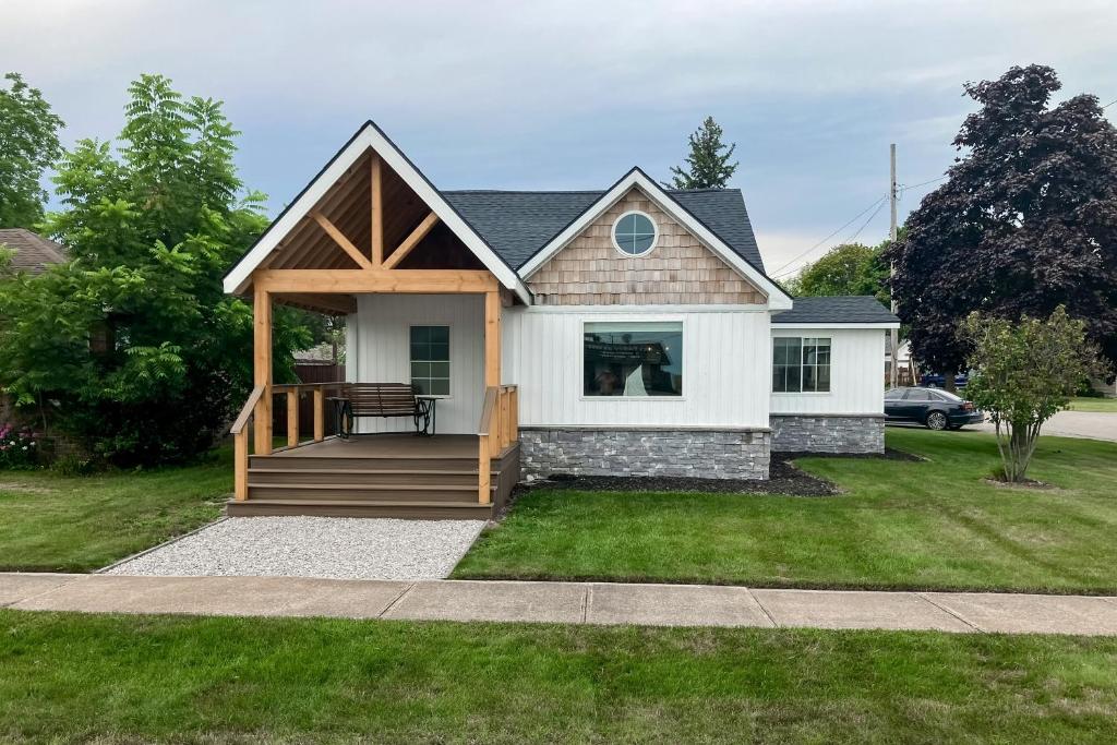 a house with a porch with a deck at Bay Street Bungalow in East Tawas