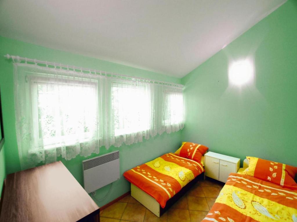 zielony pokój z dwoma łóżkami i oknem w obiekcie Holiday home by the lake, Rosnowo w mieście Rosnowo