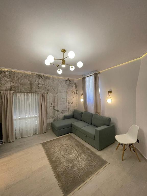 een woonkamer met een groene bank en een stoel bij Victoriei Light&Comfort in Boekarest