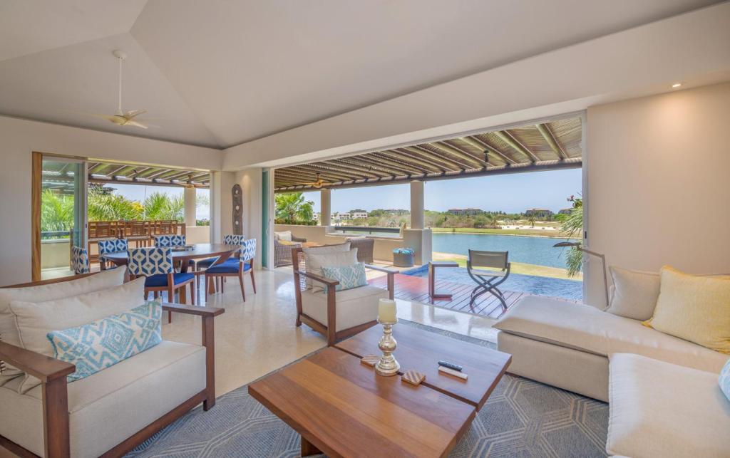 a living room with a couch and a table at PH Condo Lago in El Encanto -Lake View Penthouse with Pool Punta Mita in Punta Mita
