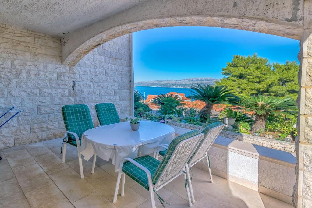 een tafel en stoelen op een balkon met uitzicht op de oceaan bij Apartments Paco in Postira