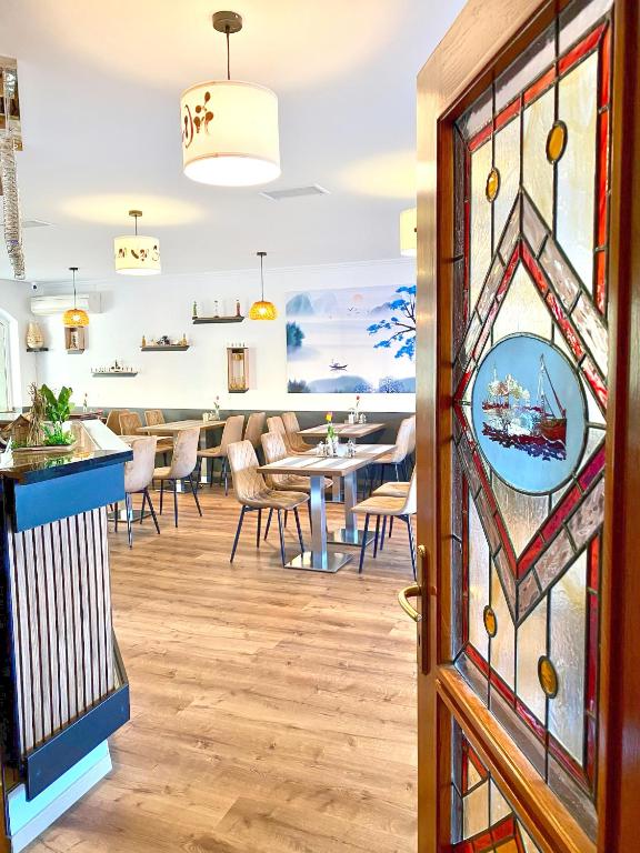 a dining room with a stained glass door at Hotel Wesselényi in Győr