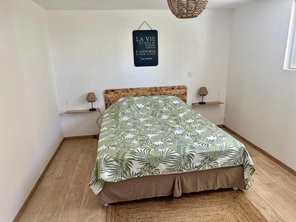 une chambre avec un lit avec une couette verte dans l'établissement Appartement cosy, à Salindres