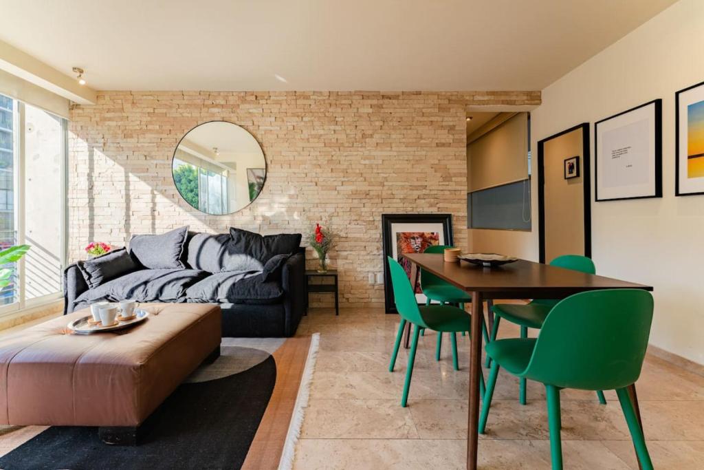 een woonkamer met een bank en een tafel bij Brick apartment two blocks from plaza Rio de Janeiro Roma in Mexico-Stad