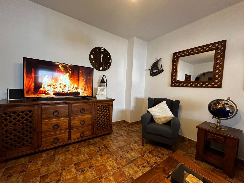 salon z telewizorem i kominkiem w obiekcie Large Apartment with AC and central heating w mieście Ardales