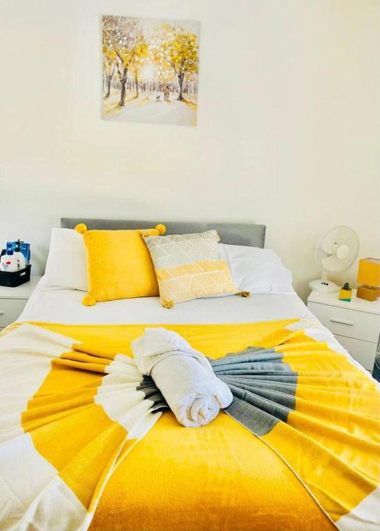 a yellow and white bed with towels on it at Alver House in Portsmouth